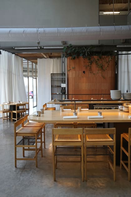 La división de ladrillo a la vista está hecha con mitades de ladrillos huecos. El mobiliario, en madera clara, incluye sillas modulares que en su versión para la mesada comunitaria ganan altura y suman un espacio guarda-carteras.