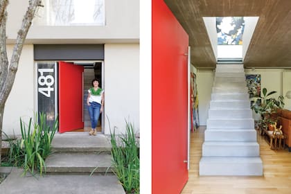 Carolina en la llamativa puerta pintada de rojo, en franco contraste con la fachada gris plana. 