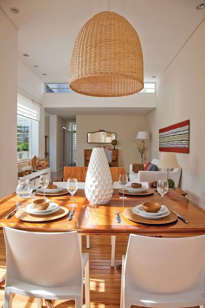 La dueña hizco la lámpara partir de una gran pantalla de mimbre. A la mesa heredada estilo Sheraton en pluma de caoba la rodearon con sillas plásticas de Mascardi, para sacarle cualquier formalidad. El pasillo lleva a los cuartos y termina en el patio.