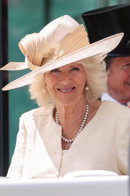 La duquesa de Cornwall optó por un vestido de gasa champagne de Fiona Clare y un sombrero de ala ancha de Philip Treacy. 