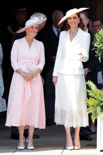 La duquesa Sofía de Edimburgo (mujer del príncipe Eduardo y cuñada del Rey) con Kate en otro evento clave del calendario royal: el Día de la Jarretera. La princesa de Gales repitió un vestido de Self Portrait con falda plisada y ruedo de encaje que ya había lucido el mes pasado en el acto por el Día de la Victoria. Le sumó un sombrero de Sean Barrett de ala ancha.