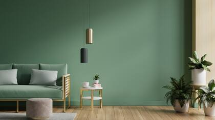 La elección de un verde en paredes se replica en el tapizado del sillón y engama con las plantas naturales