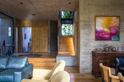 La enredadera trepa sobre tensores metálicos para resguardar las vistas desde la calle. Obra de Cristina Dartiguelongue. Puerta principal en kiri machimbrado (Carpinterías Arbesú)