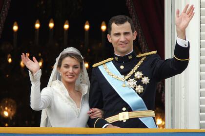 La entonces princesa de Asturias y el príncipe heredero de España saludan a la multitud desde el balcón del Palacio Oriental después de su boda, el 22 de mayo de 2004.