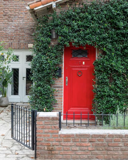 La entrada a su casa, en planta baja, es por el lateral; la puerta roja lleva a otra vivienda.