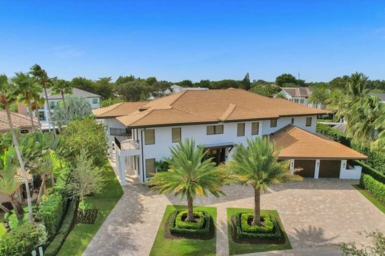 La entrada de la casa con dos palmeras típicas de la forestación tropical de la zona