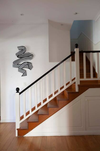 La escalera de madera se actualizó con la pintura y la obra de Sol Larrosa.