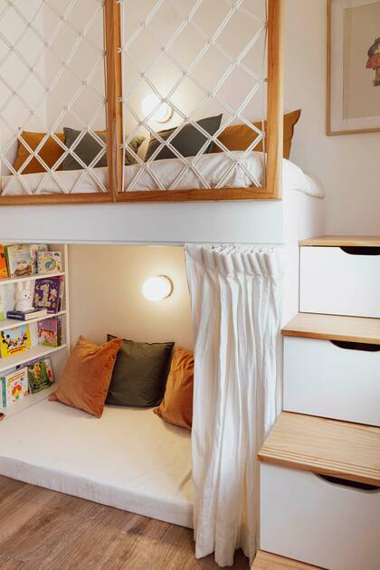 La escalerita, también de diseño propio, se resolvió con módulos de guardado. Macramé en bastidores (Mini Bags). Apliques ‘Tokio’ (Dimm). Funda de edredón (Hilo) y almohadones (Nec)