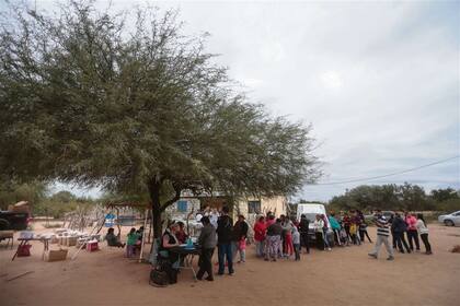 La espera. Los habitantes de Puesto Torrado y otros que se acercan de parajes cercanos hacen fila esperando ser atendidos por los profesionales, mientras unos niños se divierten en las hamacas que donaron los voluntarios