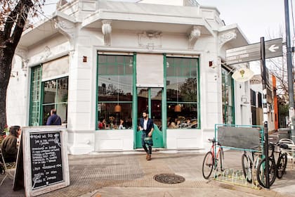 La esquina de la reciclada casona donde funciona Artemisia, con mesas en la vereda.