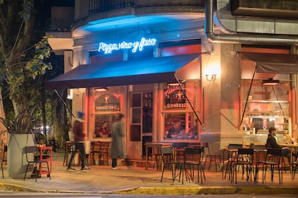 La esquina del local, con mesas adentro y afuera.