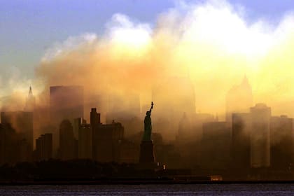 La Estatua de la Libertad se puede ver con las primeras luces desde Jersey City, Nueva Jersey, mientras el horizonte del bajo Manhattan está oscurecido por un denso humo la madrugada del sábado 15 de septiembre de 2001