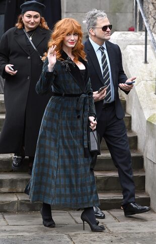 La estrella de la serie "Mad Men", Christina Hendricks, con abrigo escocés y broche en forma de lazo, saluda a los fans tras su llegada a la catedral de Southwark, Londres.