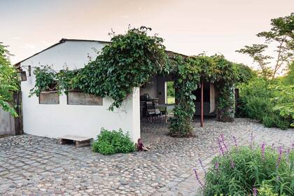 La estructura comparte con la casa el solado de adoquines y piedra bola y los canteros con saludables macizos de salvias farináceas.