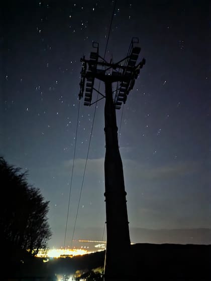 La estructura de la aerosilla se recorta contra el cielo nocturno, con la ciudad de Ushuaia iluminada al fondo