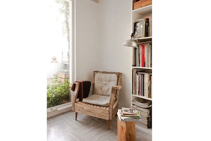 La estructura de un sillón viejo al desnudo se convierte en un asiento rústico y canchero para armar un rincón de lectura en el living de tu depto