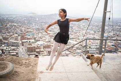 La estudiante de ballet Keith Chávez, de doce años, actúa en el barrio de San Genaro en el distrito de Chorrillos, al sur de Lima, el 1 de abril de 2023. En una colina árida y seca de Lima, un grupo de niñas con leotardos se ponen de puntillas en un camino rocoso y polvoriento. Casi ninguna de ellas llegará a ser bailarina profesional, reconoce sin amargura María del Carmen Silva, instructora del ballet que se financia con el reciclaje, en Perú