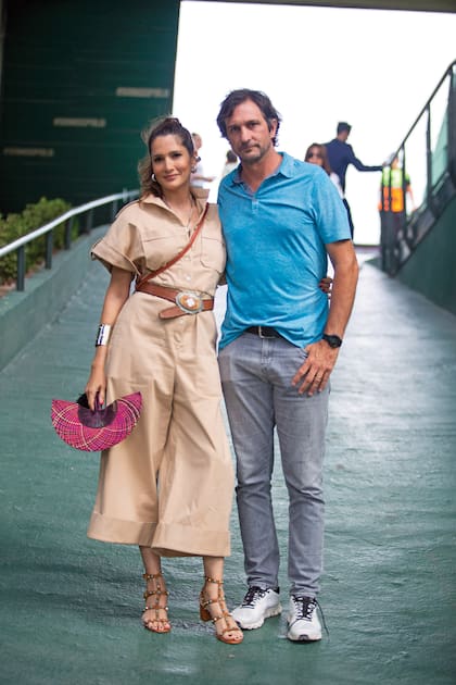 La ex top model Astrid Muñoz -con mono pantacourt, abanico de rafia y sandalias Valentino- y Eduardo Novillo Astrada, infaltables.