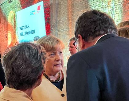 La excanciller alemana Angela Merkel habla con Britta Hasselmann y Wolfgang Schmidt en la despedida del presidente de la DGB, Reiner Hoffmann. Photo: Basil Wegener/dpa