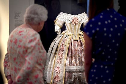 La reina de Inglaterra observa un traje que fue utilizado para la gala "Stuart Ball" en 1851