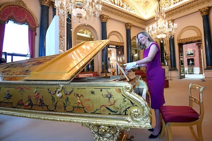 La curadora Amanda Foreman posa junto al piano de la Reina Victoria