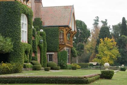 La fachada de la casa principal, cubierta de enredadera.