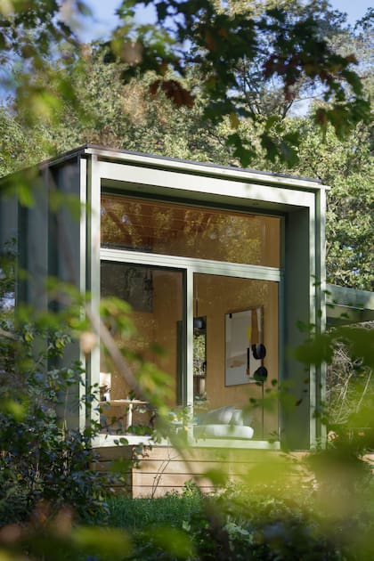 La fachada vidriada se abre al verde y deja que el paisaje forme parte del interior.