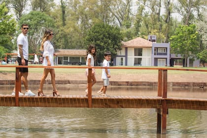 La familia Paredes al completo camina por el puente que atraviesa la laguna artificial que hay en la chacra. La propiedad fue comprada por el futbolista hace dos años y ahora planea regalársela a su mamá.
