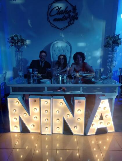 La familia posando en la mesa principal del salón, especialmente decorado para la celebración