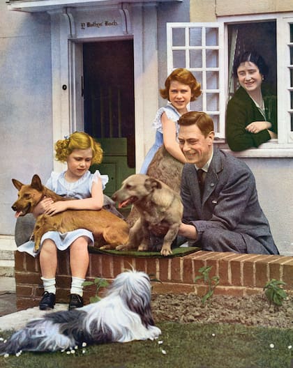 La Familia Real en Windsor, en los años 30. El rey Jorge VI y la reina Isabel (madre) con sus dos hijas, las princesas Isabel -junto a la ventana, quien luego sería reina- y Margarita -sentada-. La vida en las afueras de Londres las convirtió en apasionadas por los caballos y los perros. 
