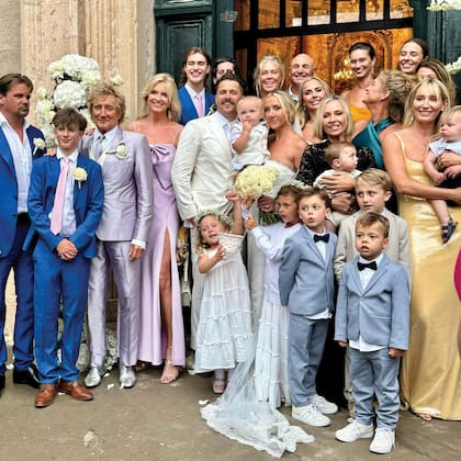 La familia Stewart al completo. Rod (con traje gris) y Penny (con un vestido lila) junto a los novios (Nicole sostiene en sus brazos a Louie, su primogénito de un año), sus otros siete hijos –Sarah Streeter, Kimberly, Sean, Ruby, Renne, Alastair y Aiden– y su ex mujer, Rachel Hunter (que mira hacia atrás, con un vestido verde esmeralda).
