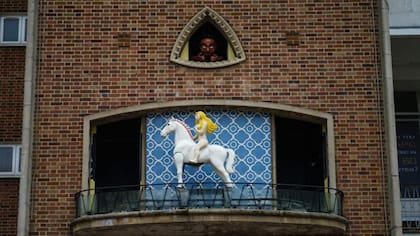 La figura de Lady Godiva en un reloj en el centro de Coventry, con un "peeping Tom" mirándola desde arriba.