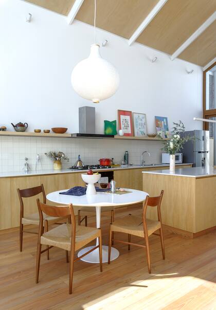 La fila de spots al filo del cielo raso iluminan la madera para crear un ambiente único al caer el día