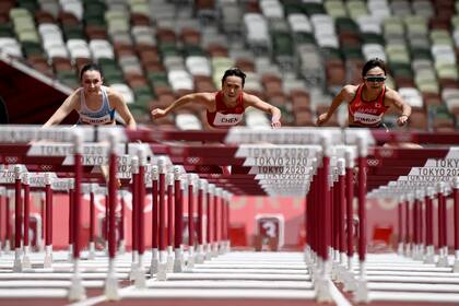 La finlandesa Reetta Hurske, la china Jiamin Chen y la japonesa Ayako Kimura compiten en las eliminatorias femeninas de 100 metros con vallas.