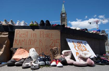 La foto de archivo del 31 de mayo de 2021 muestra zapatos en un monumento tras el hallazgo de restos de niños en el lugar donde se encontraba una escuela residencial para niños indígenas en Kamloops, Columbia Británica, Canadá. 
