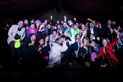 La foto final de los invitados, con vinchas y guirnaldas de flores del cotillón, y el beso de los recién casados
