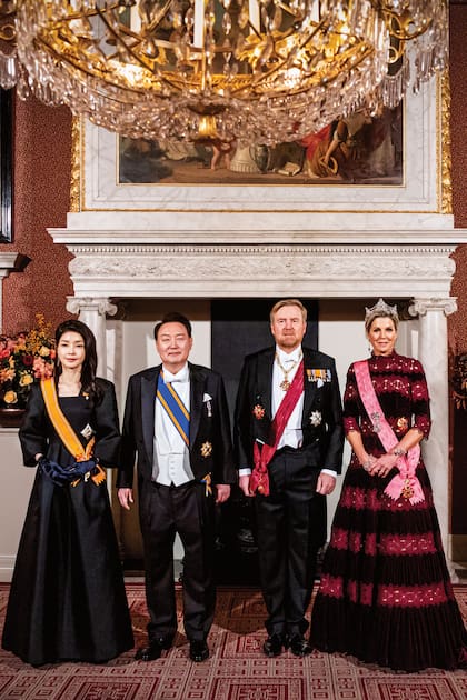La foto oficial que los reyes de Países Bajos se tomaron con el presidente Yoon Suk-yeol y su mujer, Kim Keon-hee, antes del banquete de honor. Para destacar la tiara Mellerio, Máxima vistió un diseño de terciopelo bordó, adornado con bandas de encaje de guipure que provocan un efecto “agujereado” de la firma Costarellos, que había estrenado durante su visita a Grecia, en octubre del año pasado.