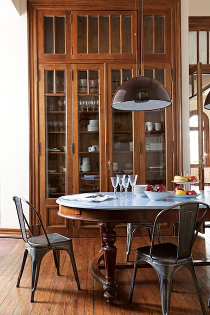 La fotógrafa Verónica Ruiz logró conjugar lo antiguo y lo actual con sensibilidad escenográfica. Aquí, una mesa de comedor antigua con la la tapa pintada de celeste fue puesta en diálogo con sillas de chapa de impronta industrial.