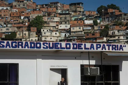 La frase "Sagrado suelo de la patria" cubre una oficina administrativa en un mercado mayorista de alimentos, cerca de un barrio de chabolas en Caracas