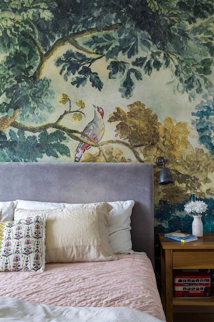 La fuerza del empapelado (Anthropologie) convive con textiles neutros (almohadones Rapsodia y ramos generales). Las mesas de luz son de Motif Deco y la cama Alix Ruiz Duggan.
