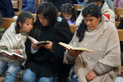 La futura primera dama de Perú, Lilia Paredes, derecha, lee la Biblia junto a su hermana menor Yenifer y la hija de ésta, Alondra, de 9 años, durante una ceremonia religiosa el jueves 22 de julio de 2021 a la que fueron invitados los vecinos para despedirse de la familia antes de que parta hacia Lima, en la iglesia del Nazareno, en Chugur, Perú.