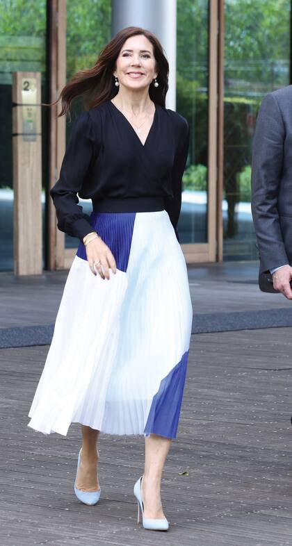 La futura reina deslumbró con una blusa cruzada de Jesper Høvring, una falda midi plisada de Designers Remix, una marca danesa comprometida con la sustentabilidad, y stilettos Gianvito Rossi. Completó el look con joyas de Dolung Fine, Julie Sandlau Fine y Halberstadt. 