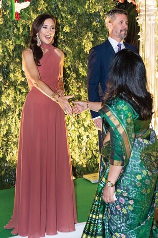 La futura reina deslumbró durante una comida de recepción en Nueva Delhi con un vestido de escote asimétrico y lazo al cuello de Søren Le Schmidt (ya lo había usado en dos ocasiones), un diseñador danés con una fuerte conciencia ecológica: el hilo conductor de las creaciones de Le Schmidt es la sostenibilidad, al igual que la temática de la gira oficial de los royals de Dinamarca.