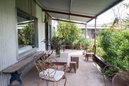 La galería de la casa hecha de chapa revela el encanto de quien trae consigo reminiscencias de la vida en el campo, con objetos con la exquisita sencillez de los materiales nobles.
