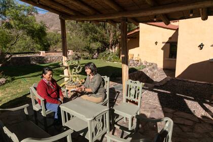 La galería de la posada se conecta con el jardín y tiene vista a los cerros.
