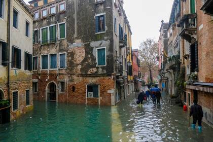 La gente camina afuera durante los niveles de agua excepcionalmente altos en Venecia