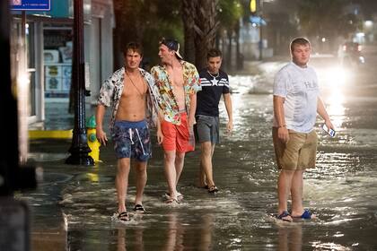 La gente camina en medio de las inundaciones en Ocean Blvd. el 3 de agosto de 2020, en Myrtle Beach, Carolina del Sur