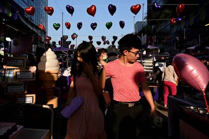 La gente camina en una calle decorada con globos en Rangún, Birmania