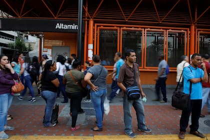 La gente camina frente a una estación de metro cerrada durante un apagón en Caracas, Venezuela.