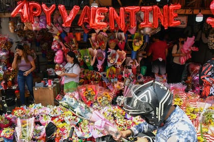 La gente compra ramos de flores por el Día de San Valentín en un mercado de flores en Manila, Filipinas